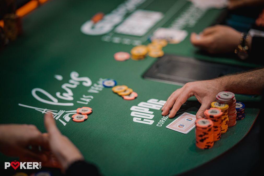 Jugador con cartas y un stack de fichas en la mesa en la WSOP